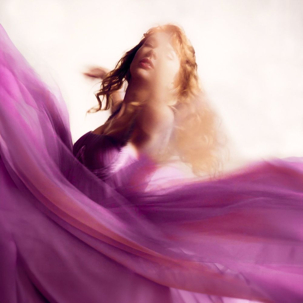 Speak Now TV era Taylor Swift. She’s posing in a purple tulle dress for the SNTV album photoshoot. 