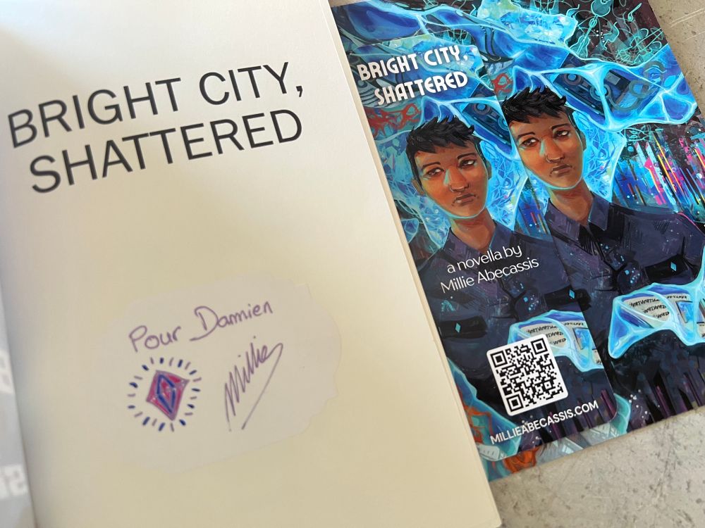 Page de garde de la novella « Bright City, Shattered » dédicacé par l’autrice, Millie Abecassis (avec en plus le marque page contenant une illustration exclusive).