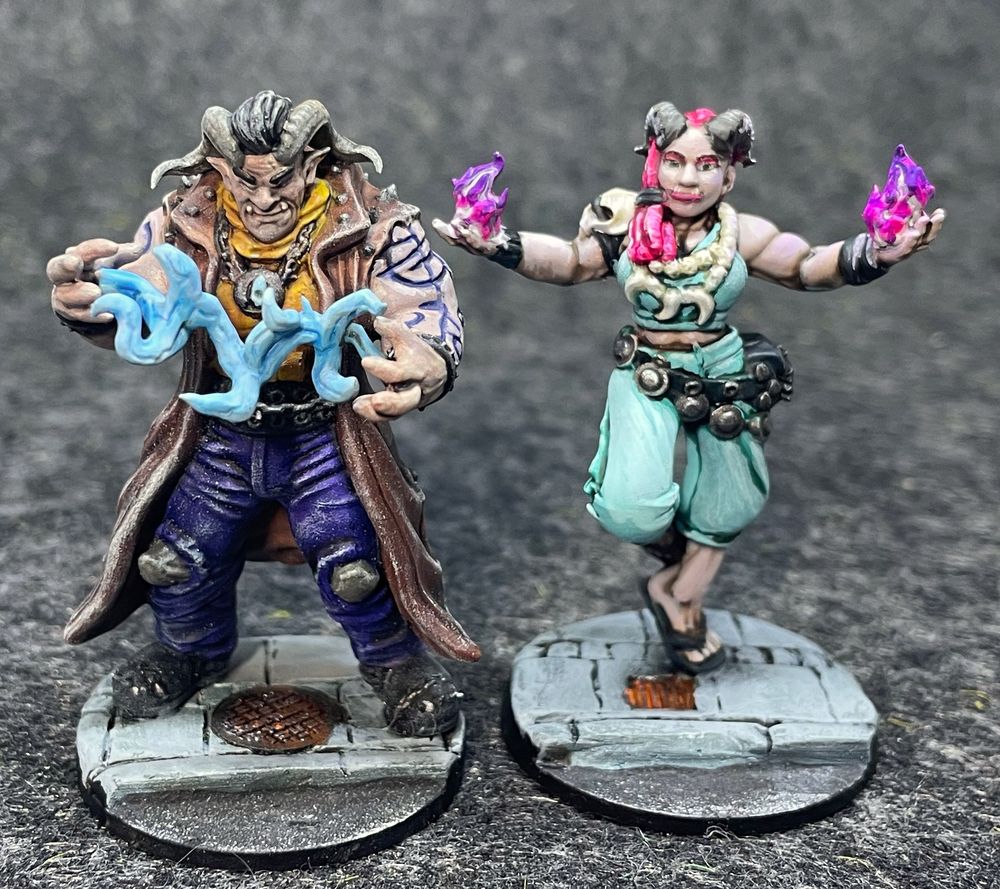Two painted Shadowrun Troll Mage miniatures. I had a lot of fun refining the look on the Lady Troll - I don't usually have the dexterity to paint eyeshadow, but since this face is about twice as large as the faces I usually paint, I gave it a go. 