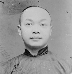 black and white photo of Wong Kim Ark, American of Chinese descent. He is looking straight at the camera.