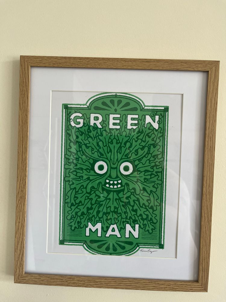 a print of a fake pub sign displaying the folkloric green man face