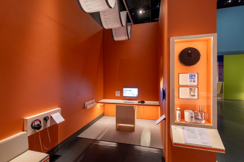 A mid shot of a nook in an exhibit with Unpacking on a computer monitor