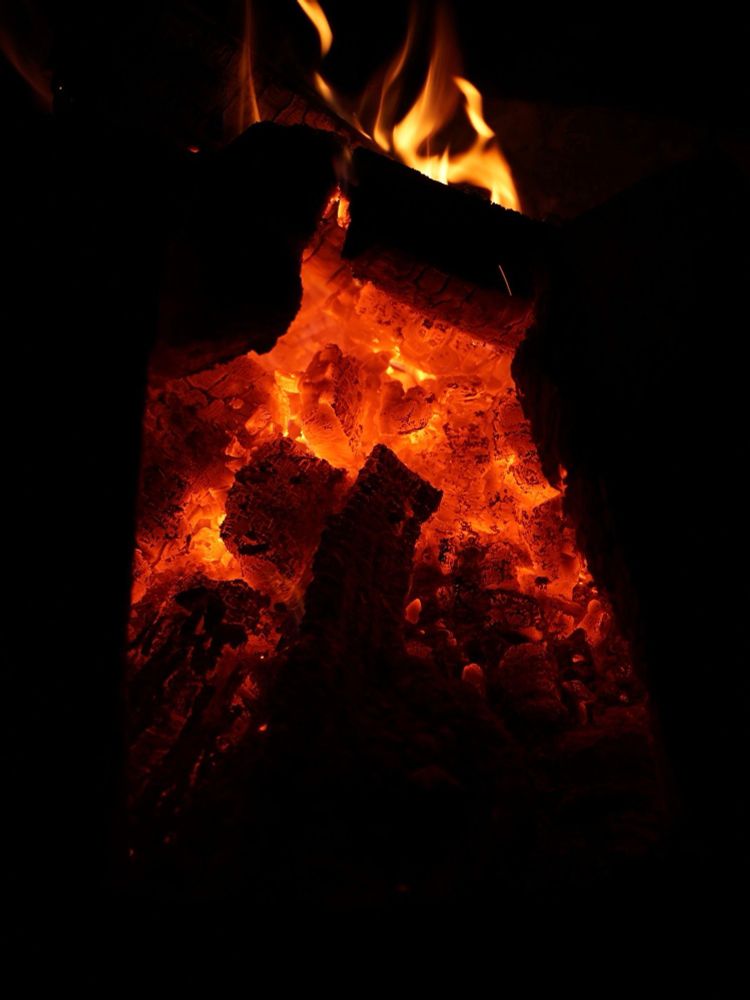 Jade's camera captures the smoldering embers of a late night camp fire. 