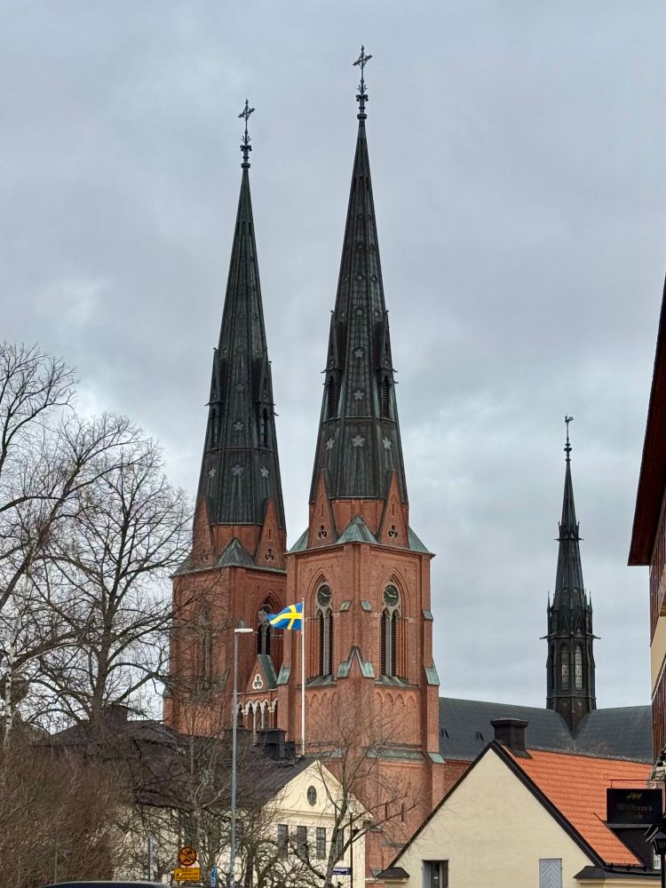 Photo of Uppsala Cathedral- with the Swedish flag in the foreground. 