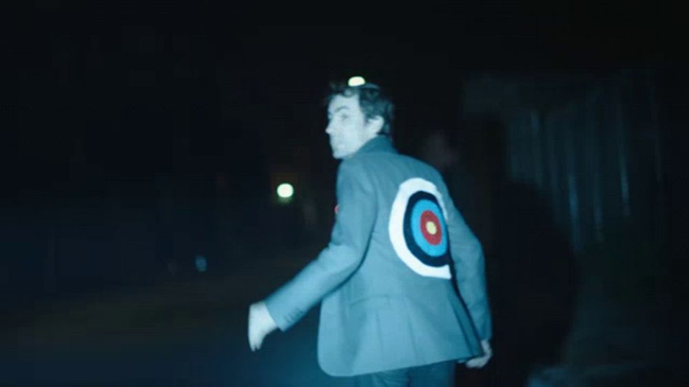 a man in a suit with a target on the back