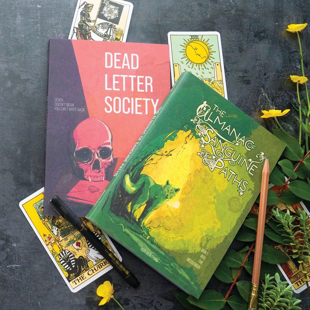 Softcover copies of Dead Letter Society and The Almanac of Sanguine Paths