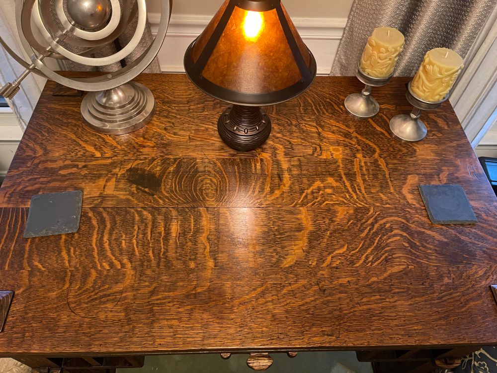 A restored antique library desk with heavy flaked quarter sawn solid top. Oiled and restored with a mica and bronze lamp sitting on top. 