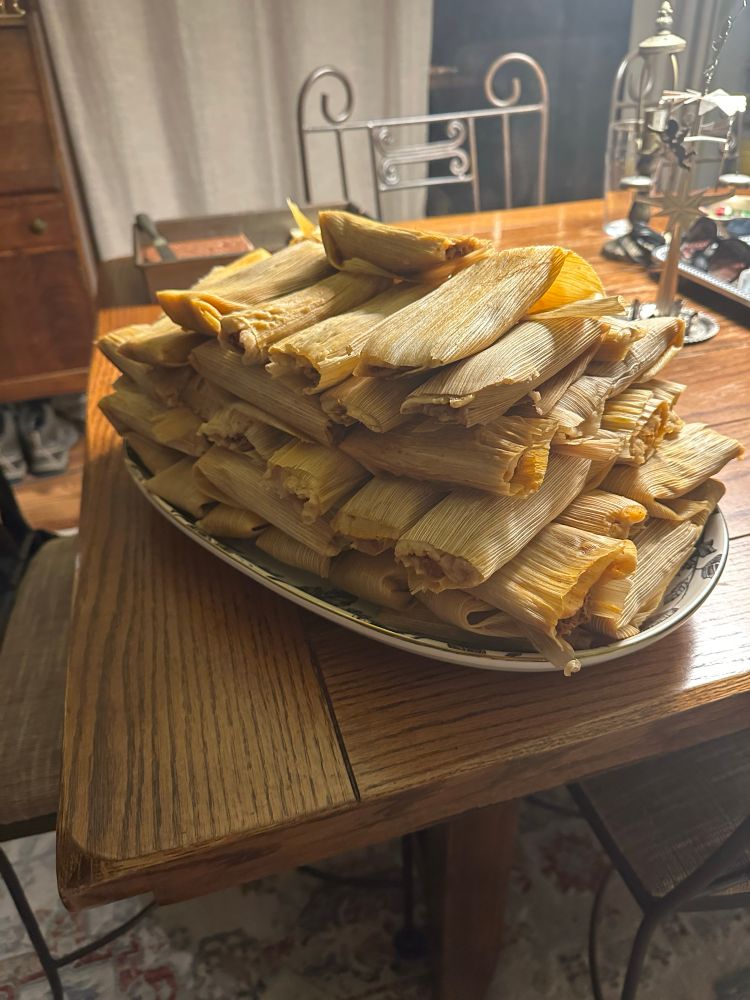 6 dozen Christmas tamales on a platter for Christmas Eve dinner on a wooden dining table. 