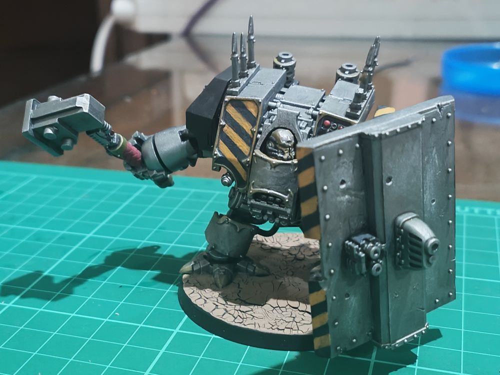 Iron Warriors Chaos Dreadnought with a thunder hammer and a shield that has a plasma gun stuck to the front