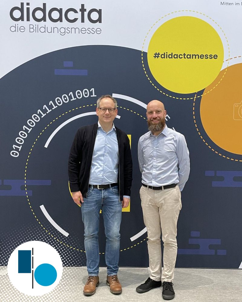 Michael Staiger und Ben Dammers vor einem Foto-Hintergrund der Didacta Bildungsmesse