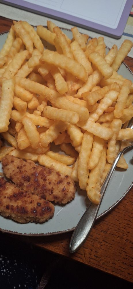 Riffelpommes und Nuggets auf einem grauen Teller. 