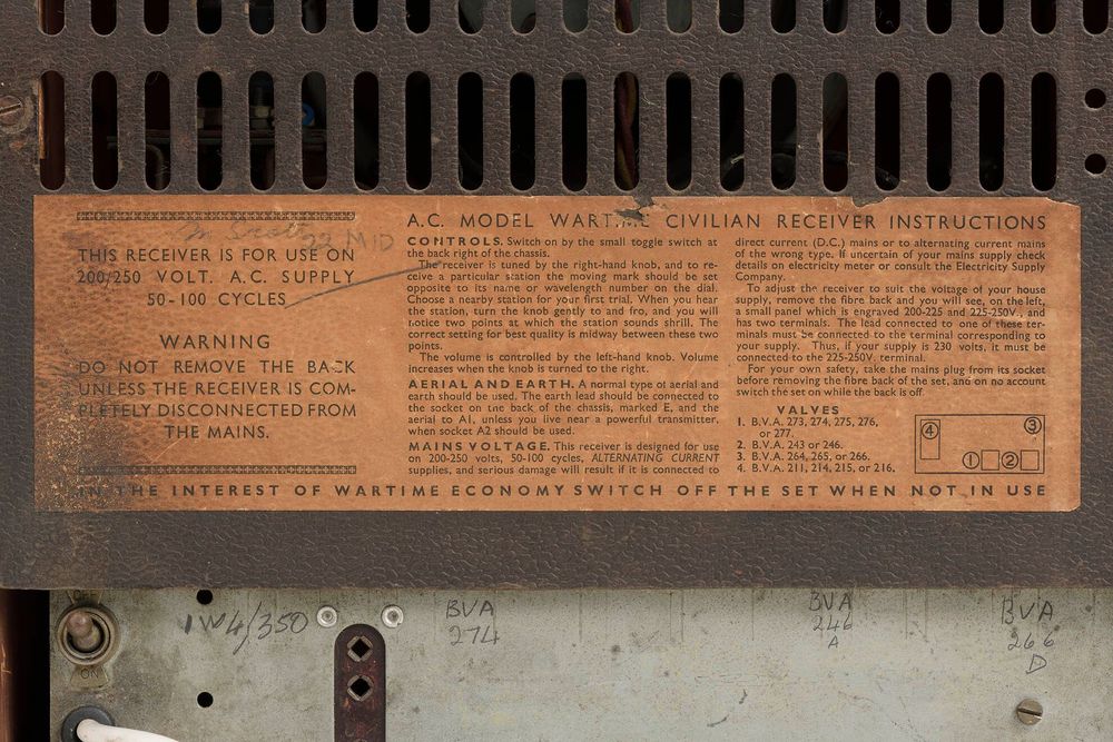 Close-up of a rear instruction label on a radio describing controls and safety notes for the A.C. Model Wartime Civilian Receiver.