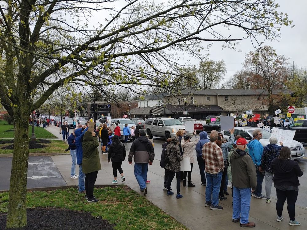 A large crowd of protesters lining both sides of a street