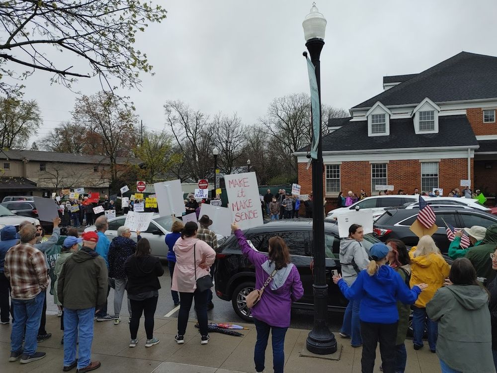 A large crowd of protesters lining both sides of a street