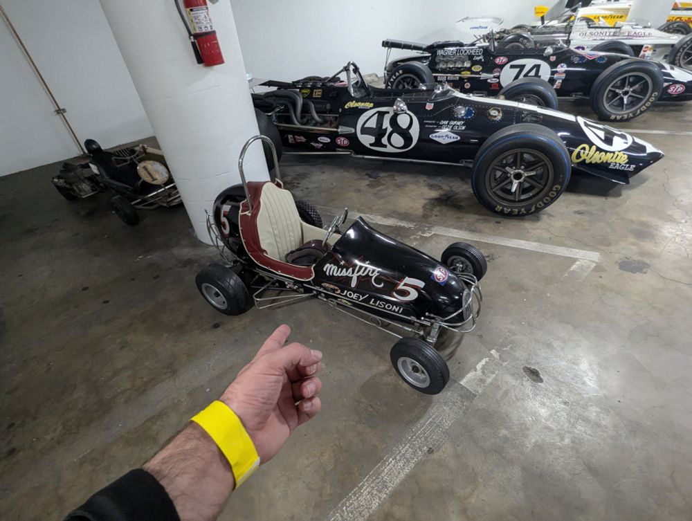 A garage full of old race cars, front stage is a particularly small one. 