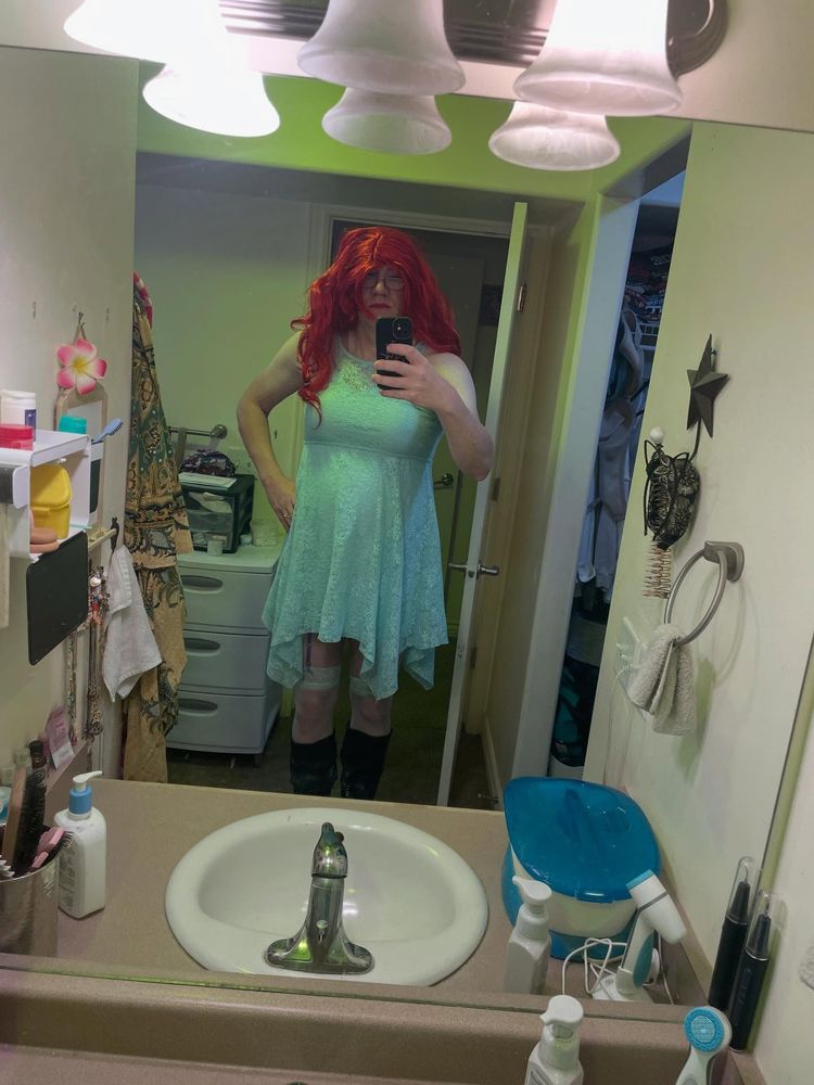 Chantel is wearing a aqua colored dress, aqua colored hold ups and 3" high heeled boots.