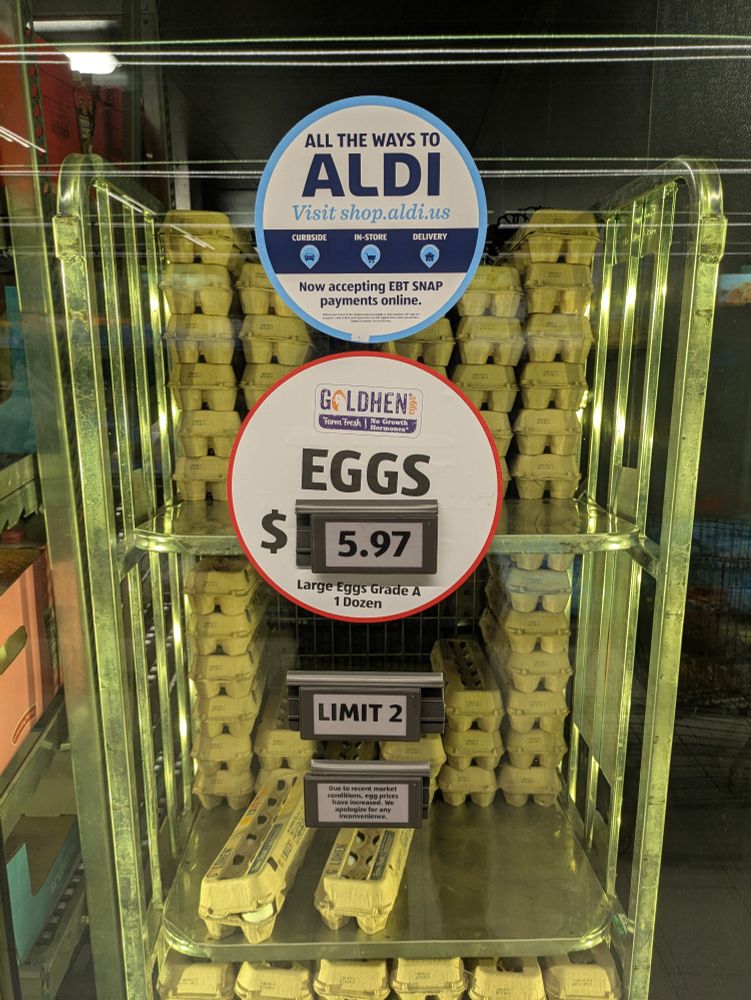 A cooler with a good supply of eggs, priced at $5.97 a dozen, and a note that says "Limit 2" 