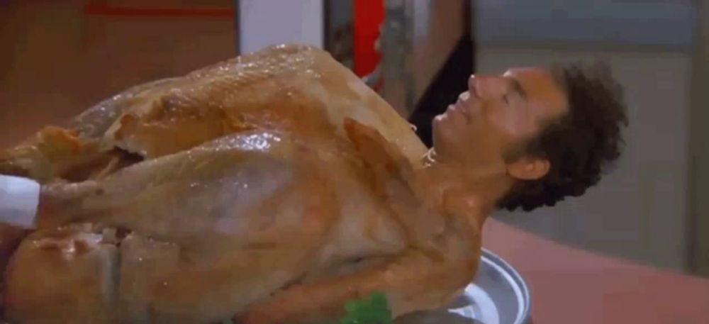 a man is laying on top of a roasted turkey