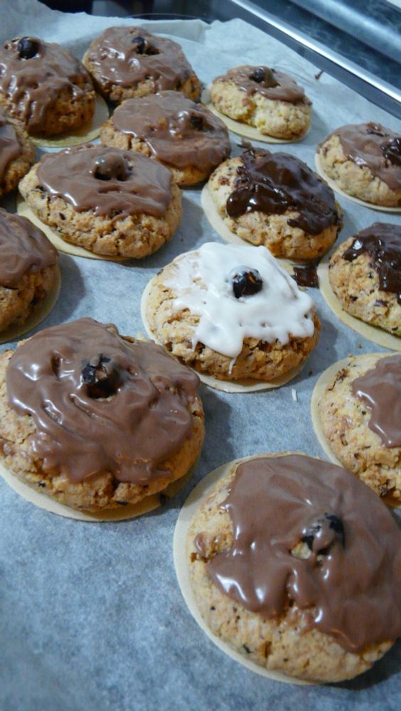 A baking tray of cookies covered in various shades of sugar and chocolate glazing.