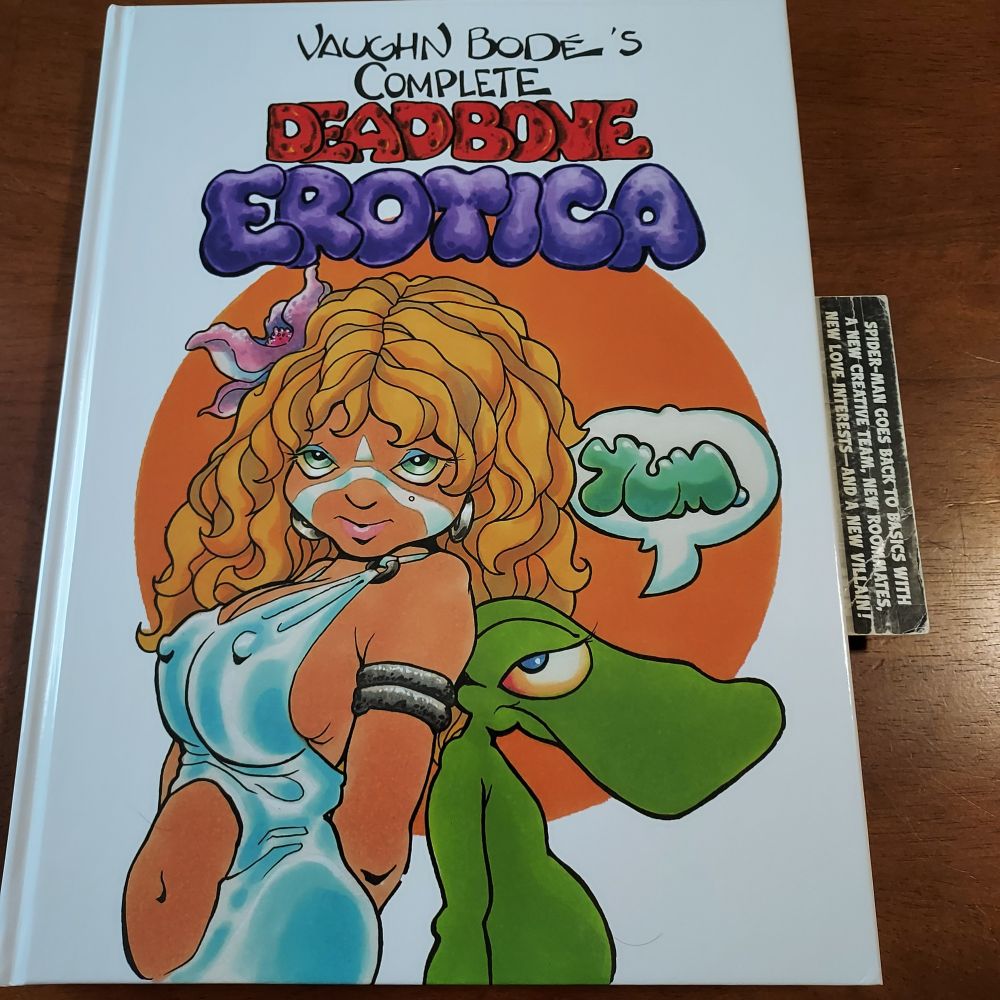Pictured is the cover of Vaughn Body's complete Deadbone Erotica, featuring a cartoon illustration of a stunningly beautiful woman and a lizard. 