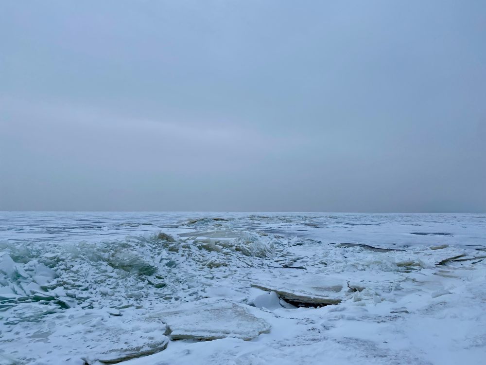 A vast, broken ice field under a cloudy sky, with no visible horizon.