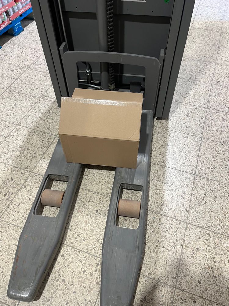 Eine e-Ameise mit einen Karton mit Papiertüten