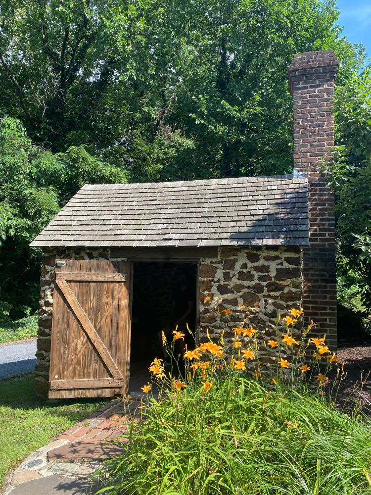 Small outbuilding made of stone with a barn-style door 