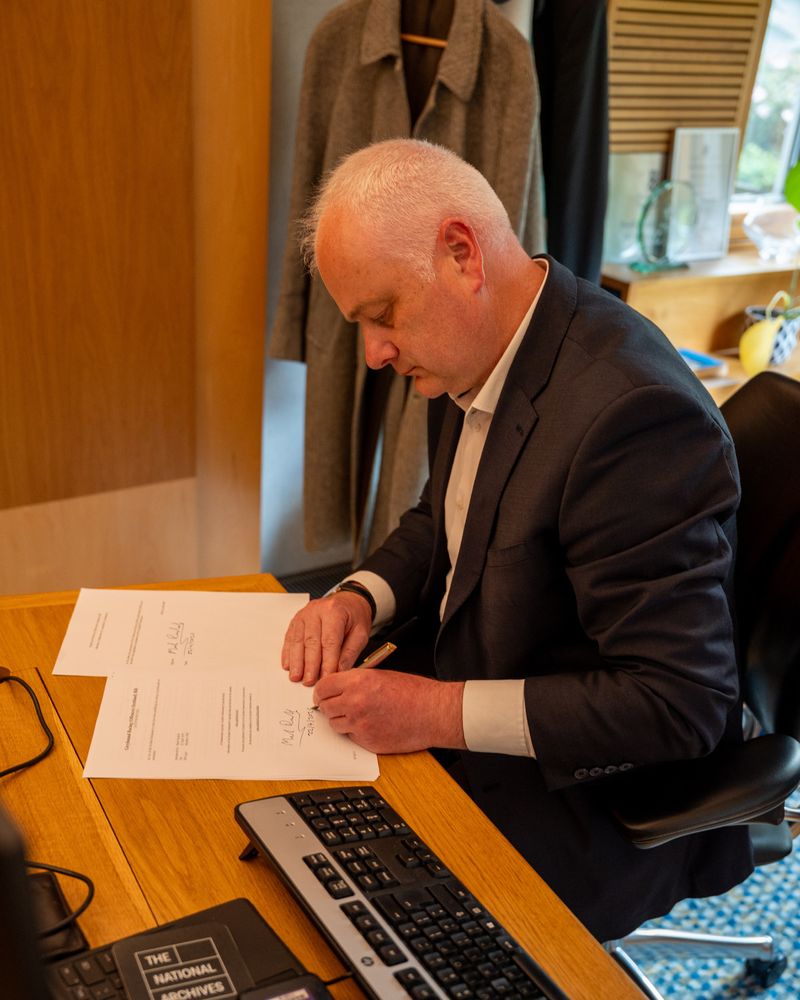 Mark Ruskell MSP signing members' bill to end greyhound racing.