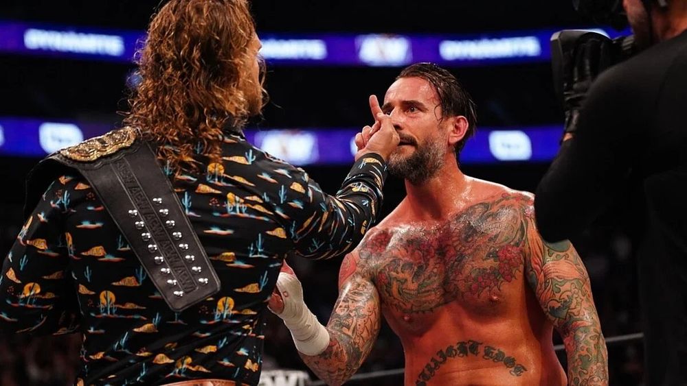 Hangman Adam Page flipping off Phil Brooks. 