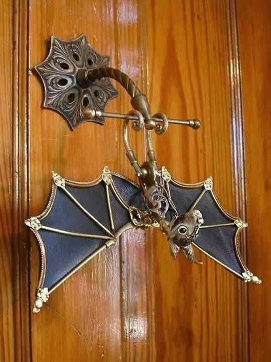 Knocker with a delicate, stylized metal bat, hanging upside down, as it should.