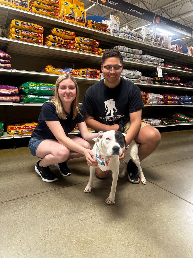 Pearl with her people! they’re crouching down next to her in an aisle, and she’s wearing a white bandana with brightly colored letters that read “it’s my gotcha day!”