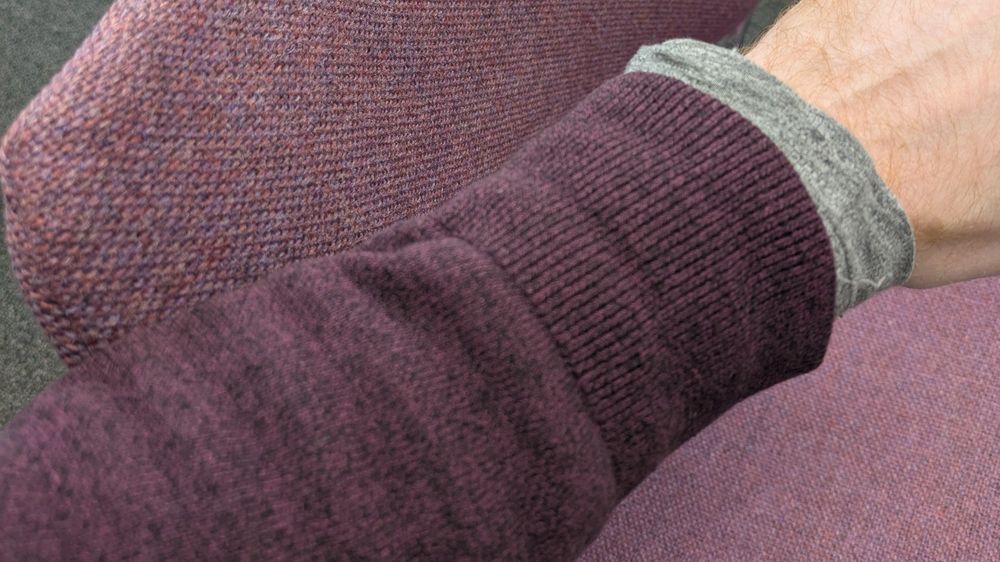 An image of a jumper sleeve the same colour as the chair.