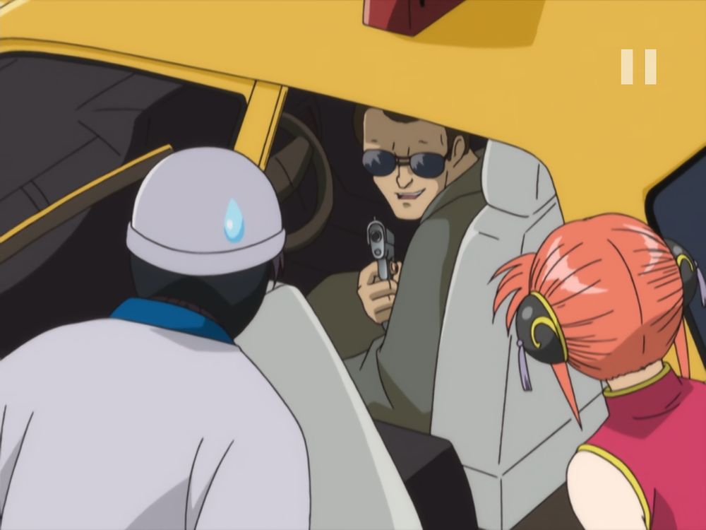 Shinpachi and Kagura try to get into a cab, only to have one of the gangsters Kagura is running from point a gun at them from the driver's seat.