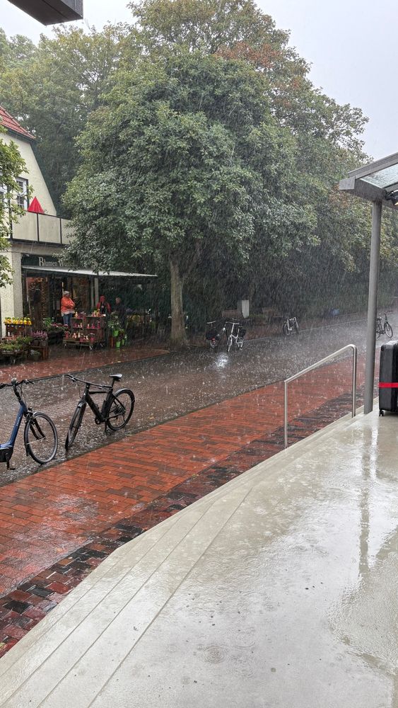 Regen platzt herunter auf eine Strasse.