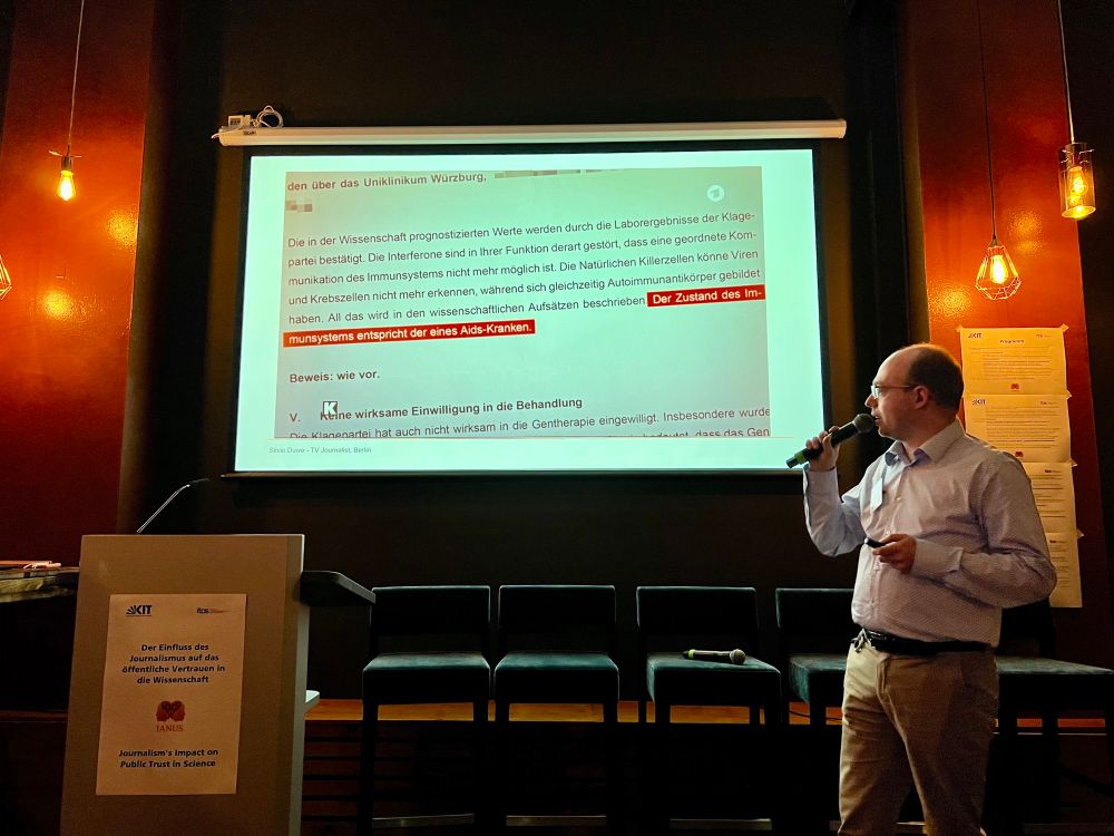 Silvio Duwe is standing in front, giving a talk and showing a slide which shows an excerpt from a legal document