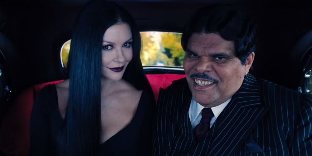 Still image from the TV show Wednesday of Morticia and Gomez Addams, played by Catherine Zeta-Jones and Luis Guzman. 