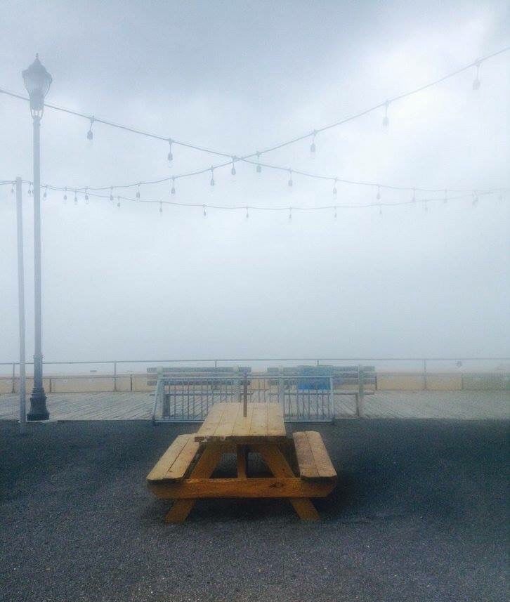 The fog rolls in and covers a lone picnic table on the Asbury Park Boardwalk.