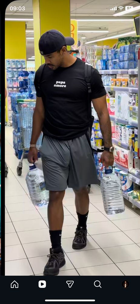 Homem de calção com uma prótese peniana fazendo volume