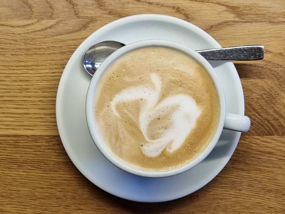 Cappuccinotasse mit Milchschaum in Form eines Auerhahns. 