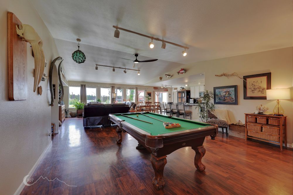 A photograph of the interior of living space with a pool table in the foreground.