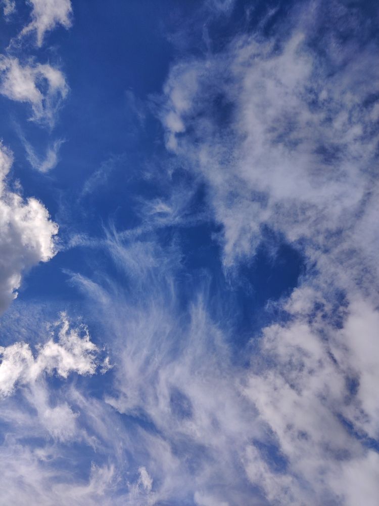 Blue sky with a thin blanket of white clouds.