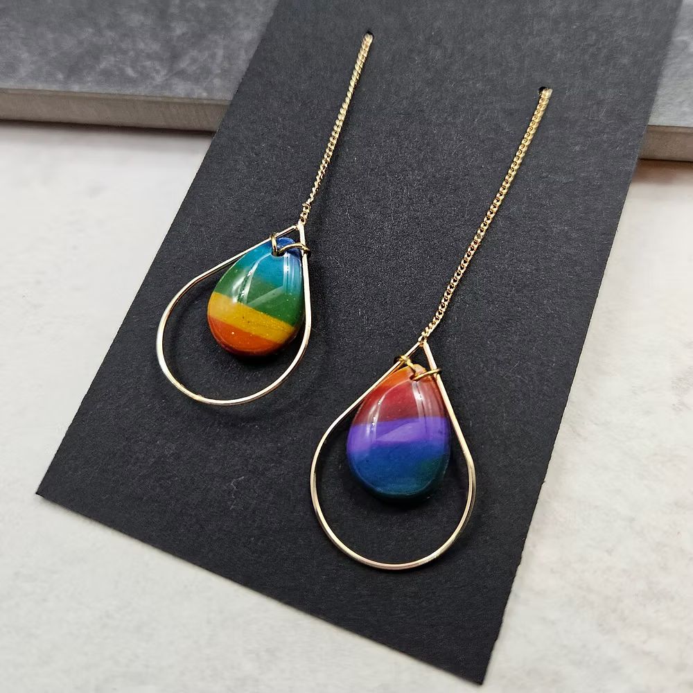 Small polymer clay teardrop dangles in rainbow stripes.