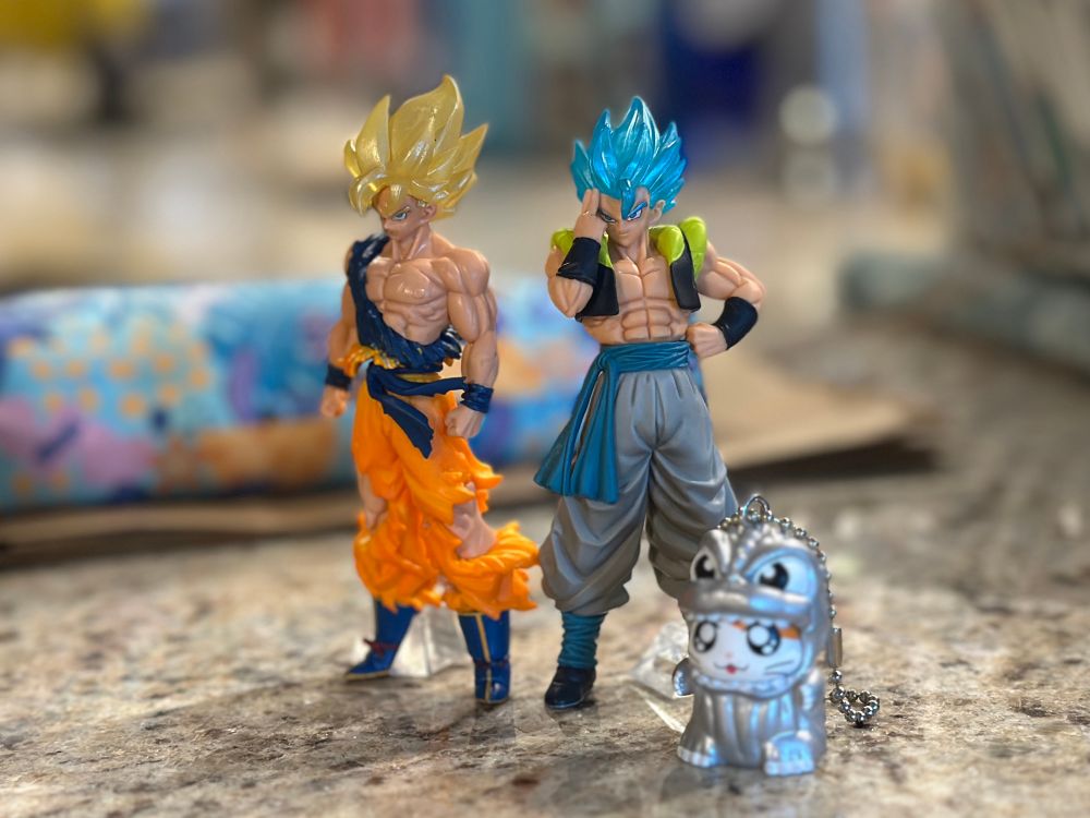 Super Saiyan Goku, Super Saiyan Blue Gogeta, and silver Godzilla Hamtaro gashapon figures. 