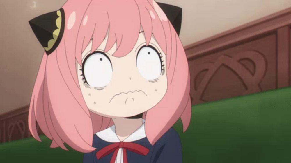 a girl with pink hair and black ears makes a surprised face