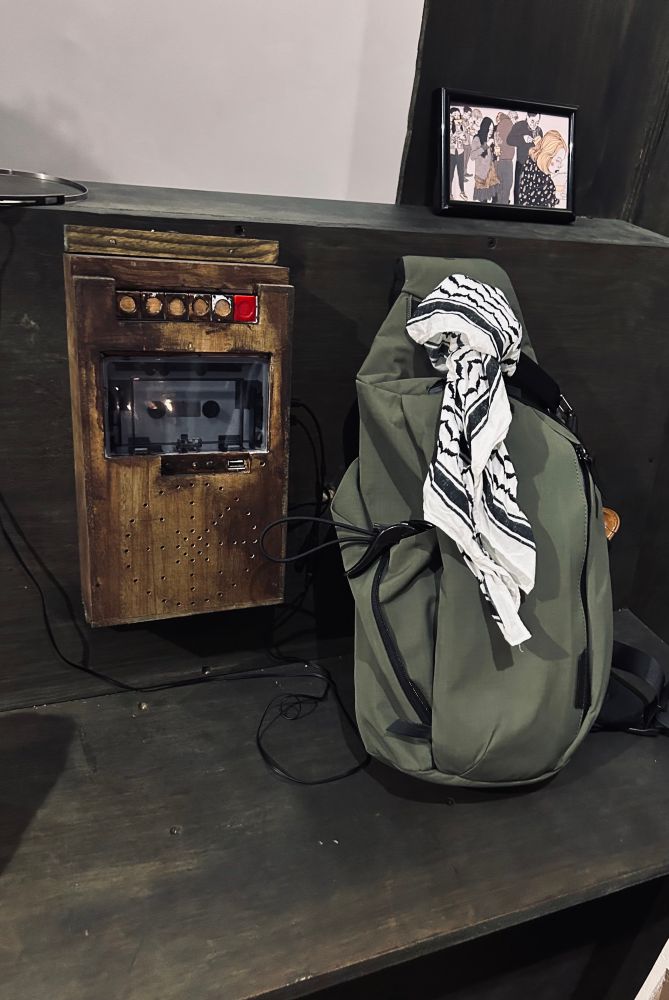 A custom made wooden cassette player with a sling bag with a Kufiya bandana