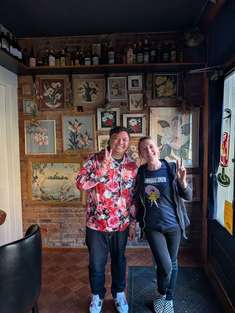A man and lady stand side by side in a bar