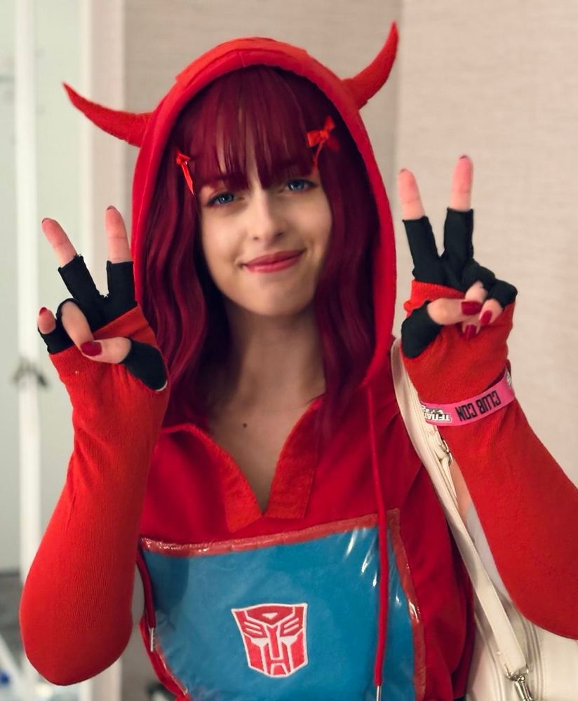 Image of a cliffjumper cosplay, posing holding up two peace signs. Attending TFNation 2025.