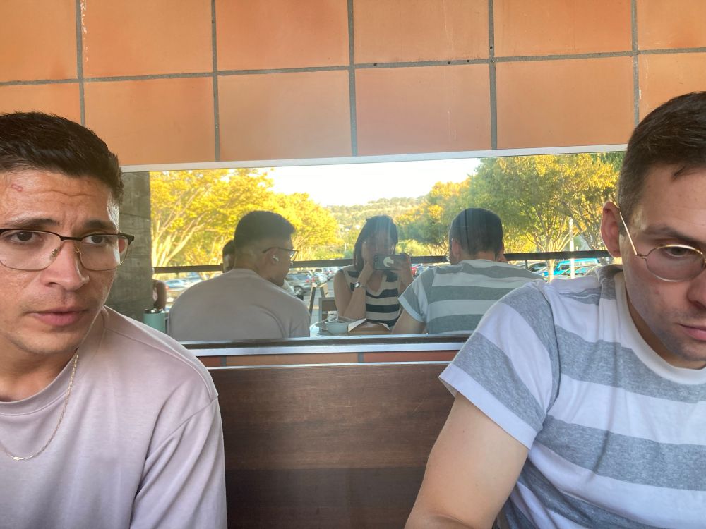 Selfie of the user in the mirror between two friends