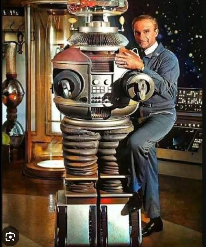 Dr. Smith posing next to the robot from in ‘Lost In Space’ tv show  