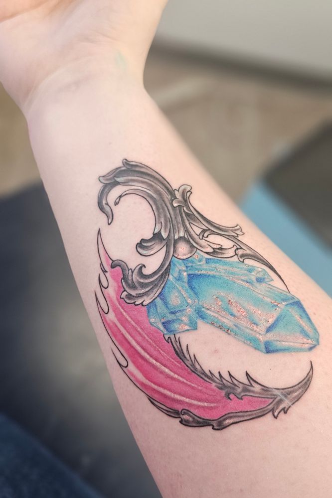 A fresh tattoo that I got. A blue crystal and a pink dragon wing are mounted on top of some art deco filigree